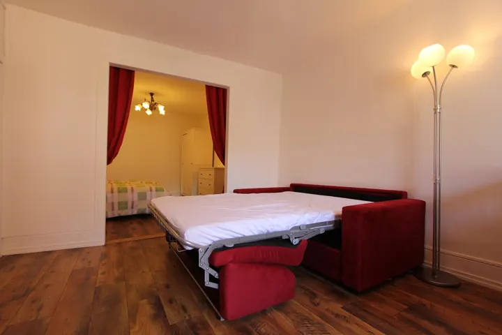 Canapé convertible du séjour ouvert, chambre en arrière-plan